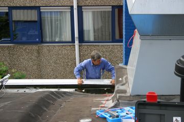 Huub via ladder naar dak